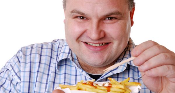 Übergewichtiger Mann isst Pommes