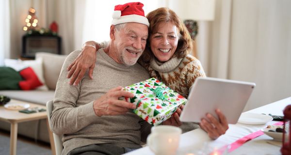 Älteres Paar chattet an Weihnachten mit den Liebsten