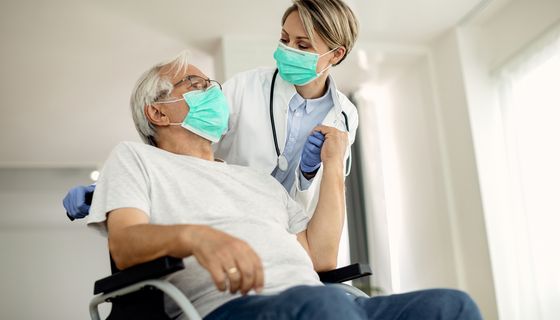 Ärztin redet mit älterem Patient.