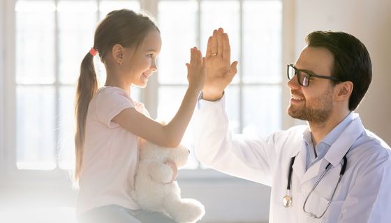 Mädchen und Arzt, geben sich ein High Five.