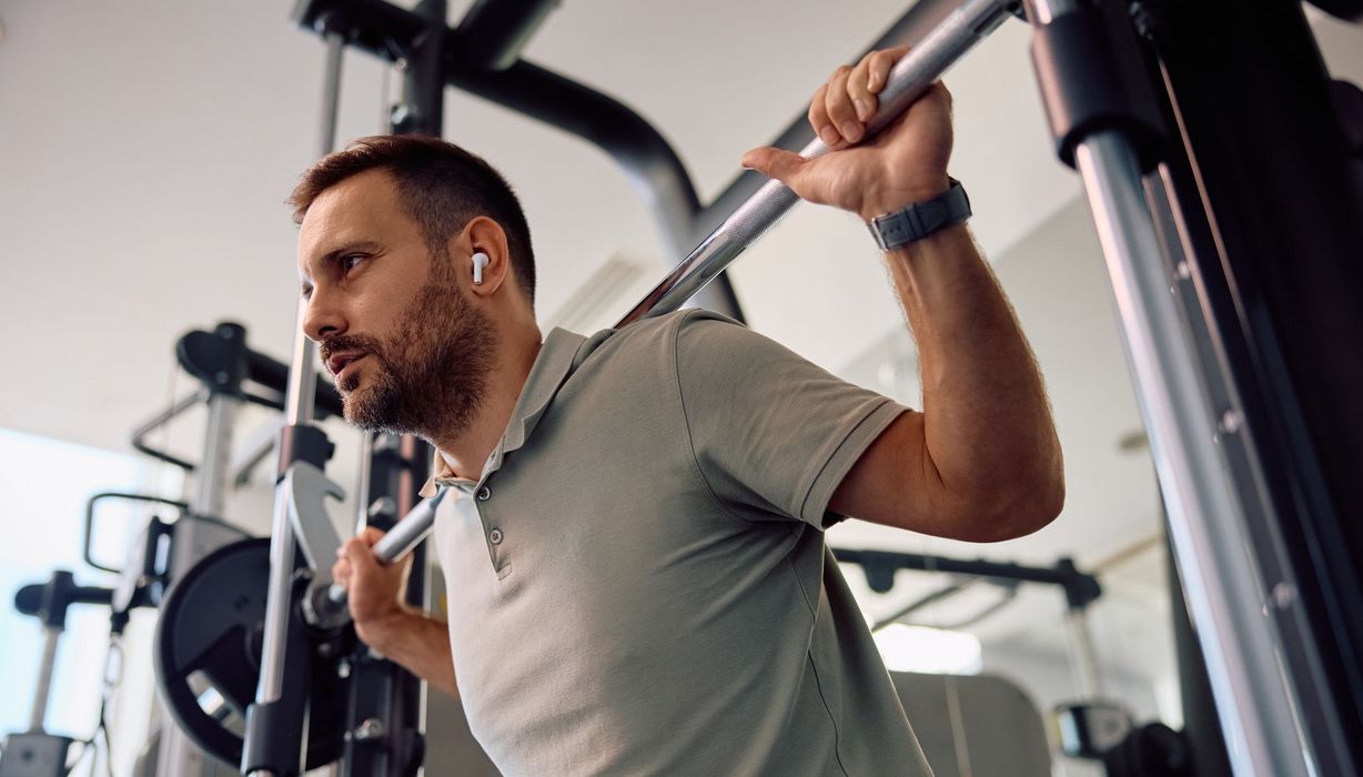 Mann beim Krafttraining mit großen Gewichten im Fitnessstudio.
