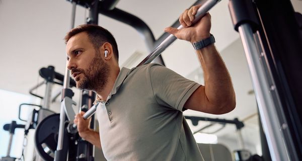 Mann beim Krafttraining mit großen Gewichten im Fitnessstudio.