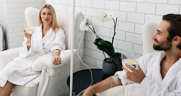 Junge Frau und junger Mann erhalten Vitamin-Infusion