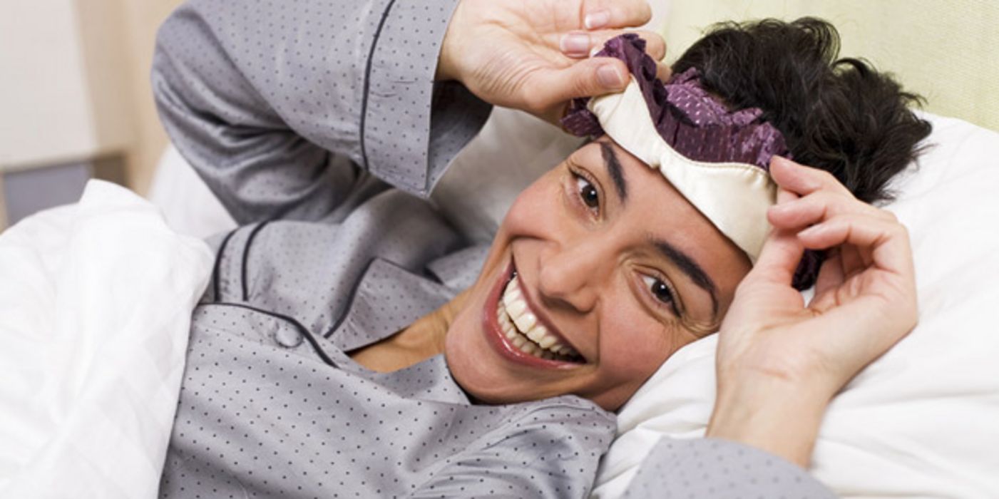 Lachende Frau im Bett
