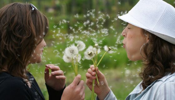 Zwei Frauen mit Pusteblumen