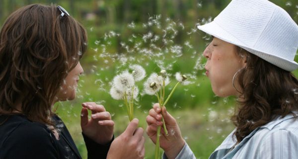 Zwei Frauen mit Pusteblumen