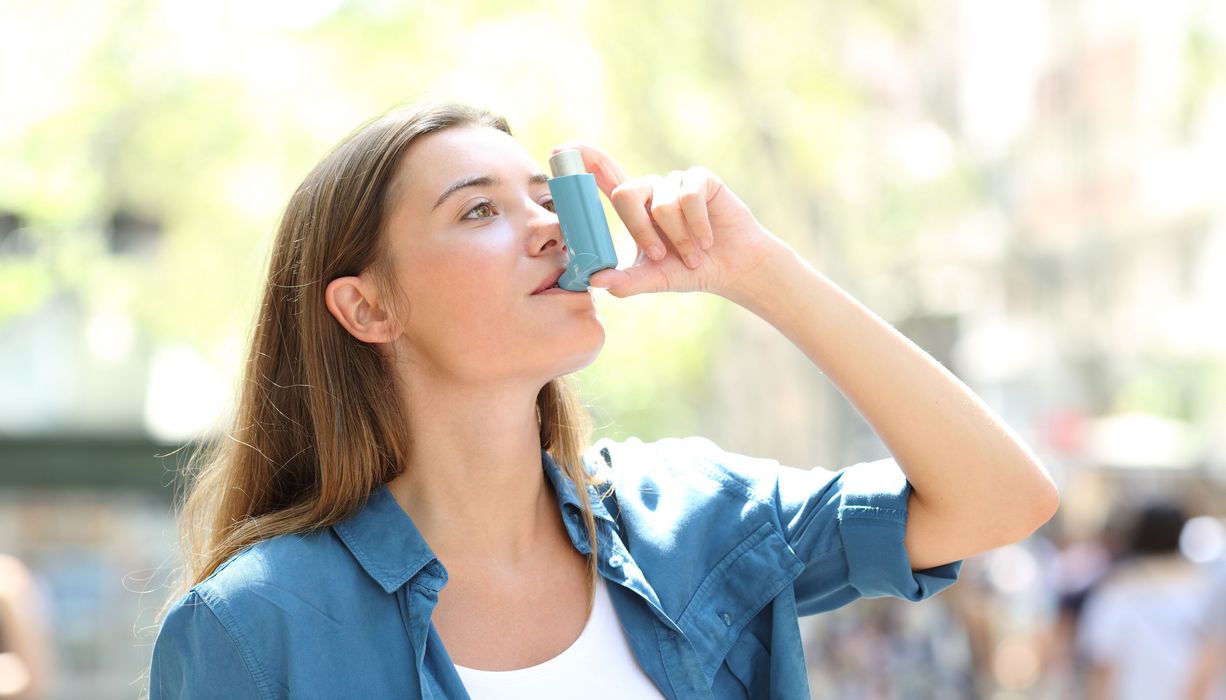 Frau inhaliert Asthmaspray.