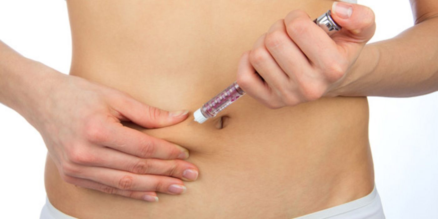 Frau spritzt sich Insulin in eine Bauchfalte