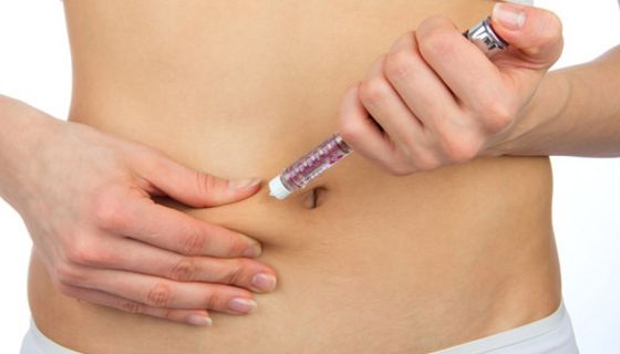 Frau spritzt sich Insulin in eine Bauchfalte