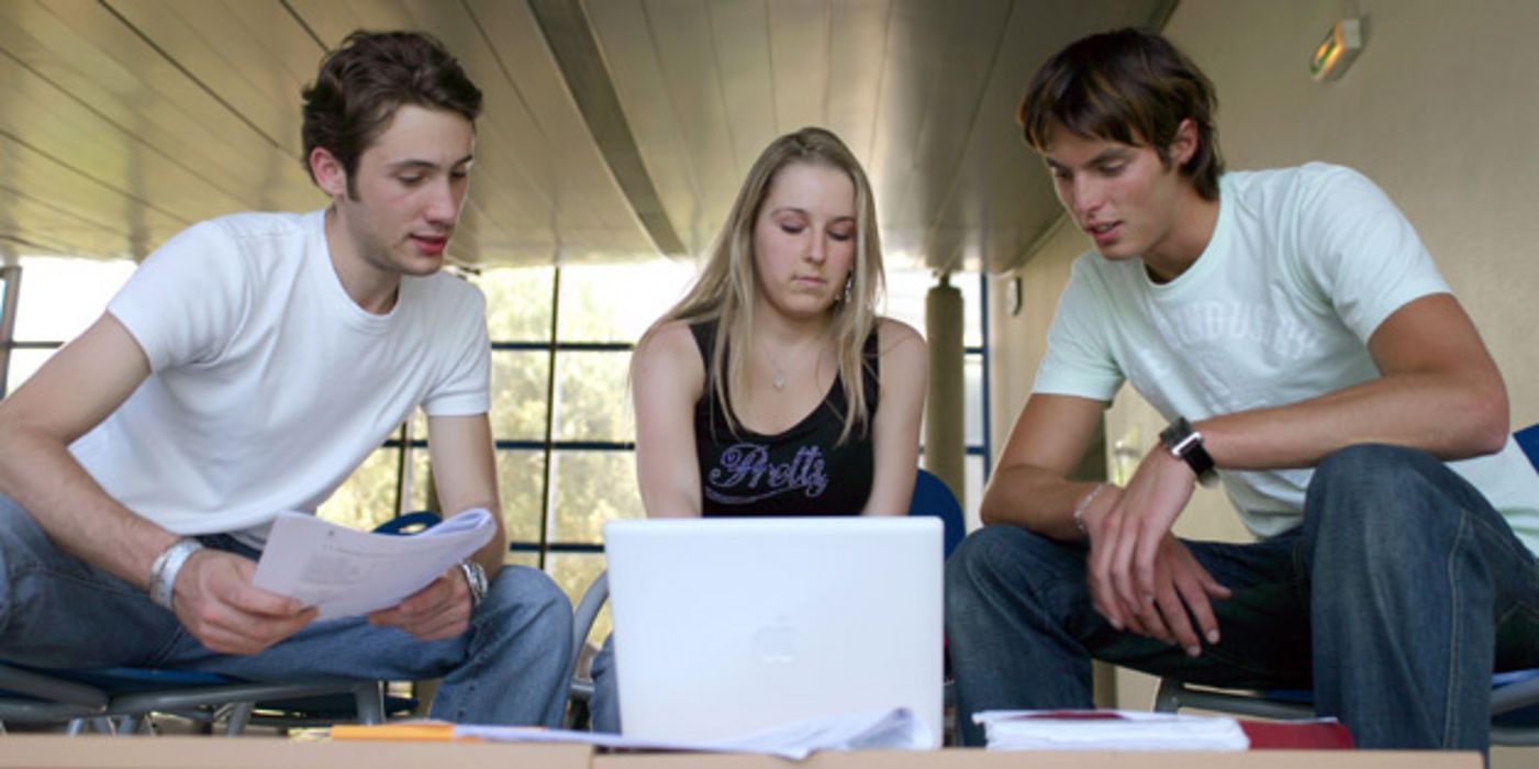 Drei junge Menschen vor einem Laptop
