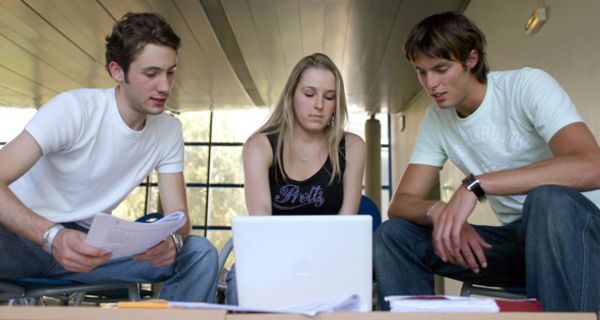 Drei junge Menschen vor einem Laptop