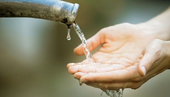 Zwei Hände unter einem Wasserstrahl