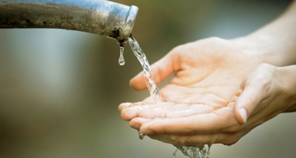 Zwei Hände unter einem Wasserstrahl