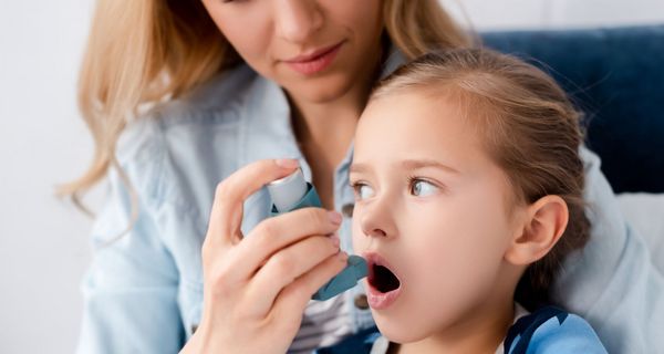 Mutter, verabreicht ihrem Kind Asthmaspray.