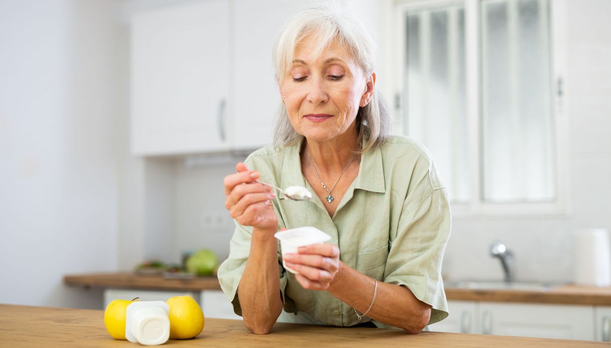 ältere Frau isst Joghurt