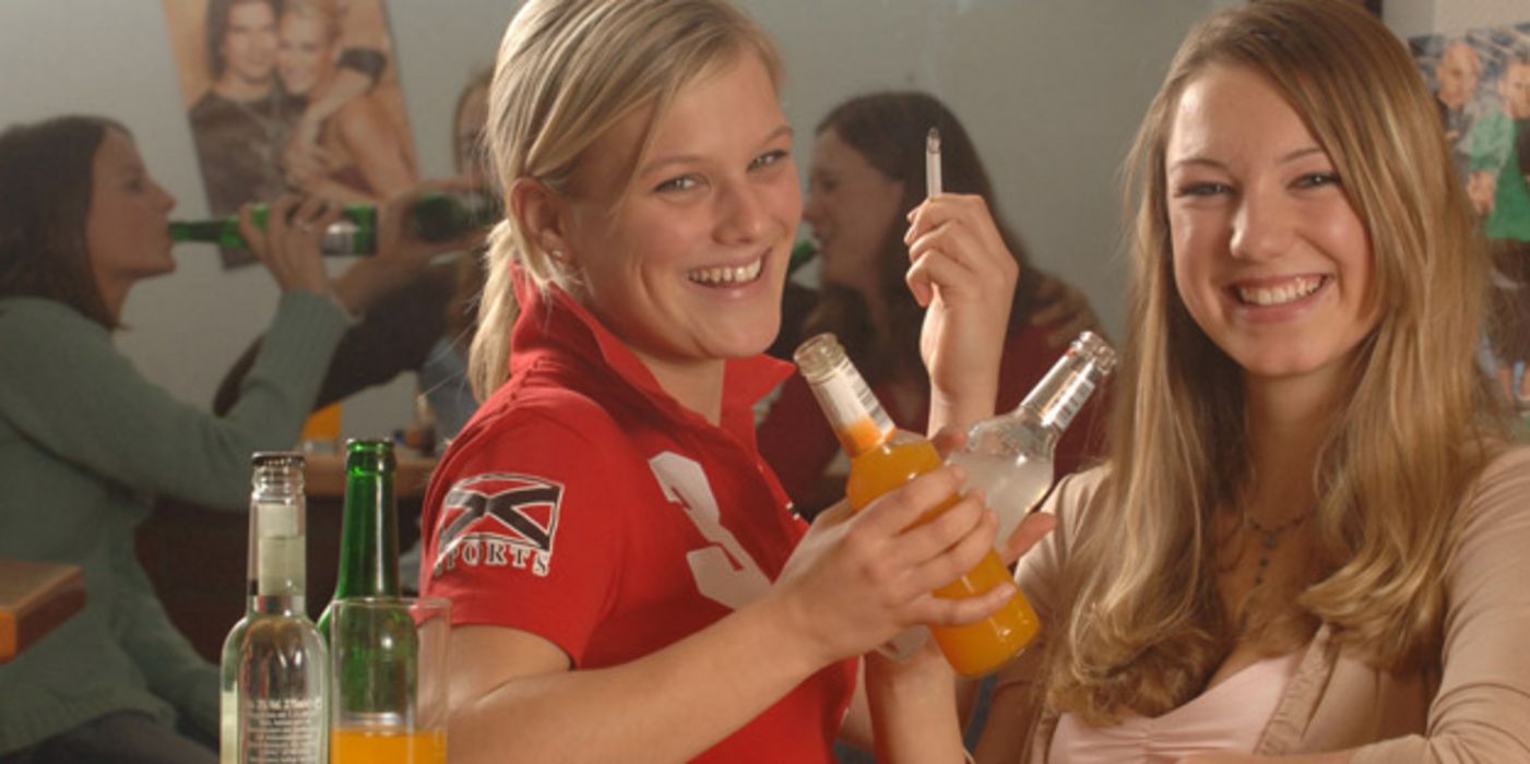 Zwei Junge Frauen rauchen und trinken Bier.