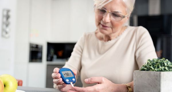 Ältere Frau misst ihren Blutzucker.