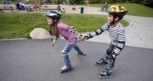 Zwei Kinder fahren Inliner.