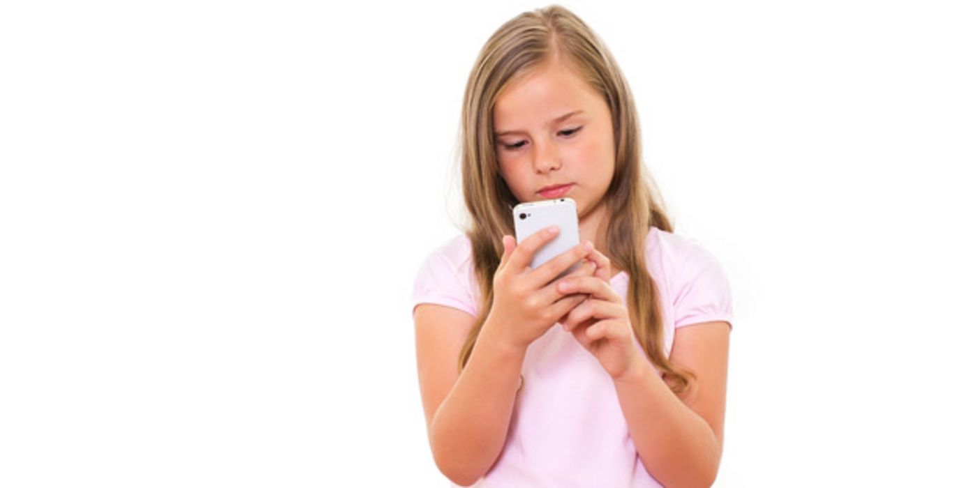 Mädchen im Grundschulalter tippt auf einem Handy