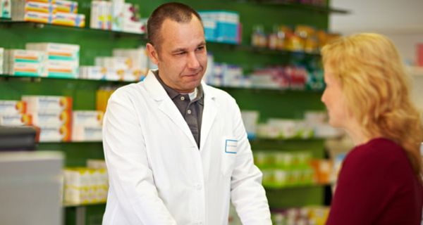 Apotheker hört einer Patientin zu