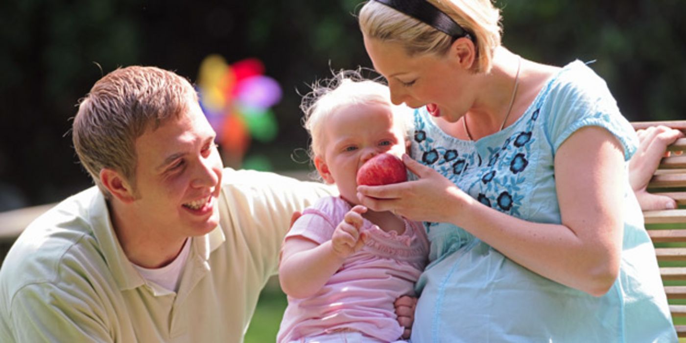 Mutter, Vater, Kind mit Apfel