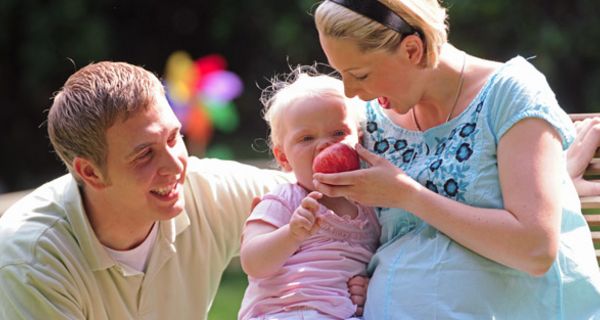 Mutter, Vater, Kind mit Apfel