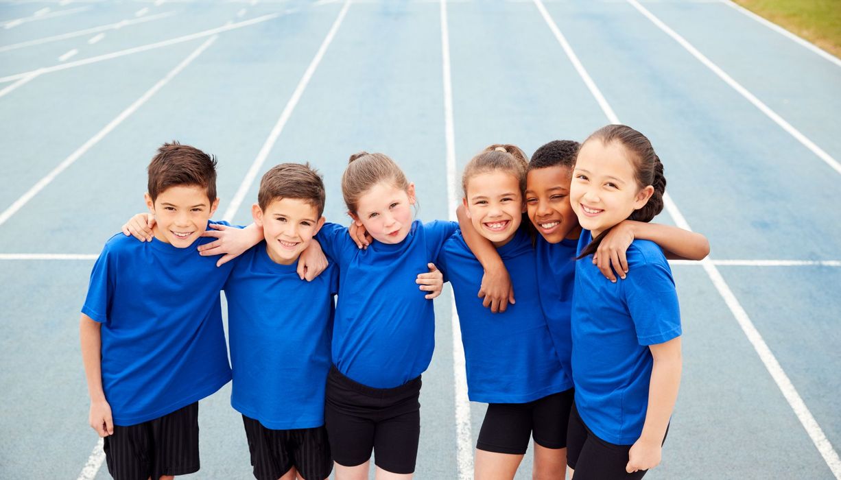 Kinder zusammen auf einem Sportplatz.