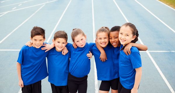 Kinder zusammen auf einem Sportplatz.