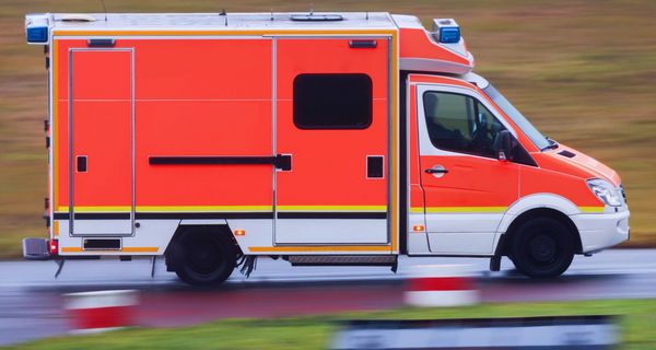 Ein Krankenwagen, der auf einer Landstraße unterwegs ist.