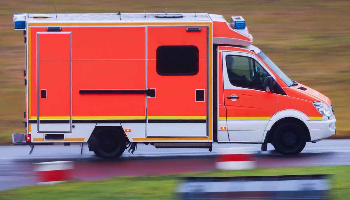 Ein Krankenwagen, der auf einer Landstraße unterwegs ist.