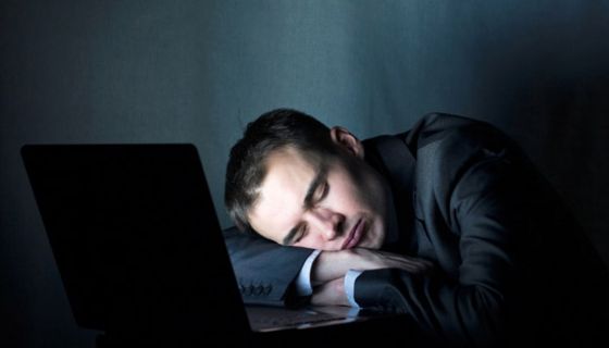 Schlafender Mann vor einem PC