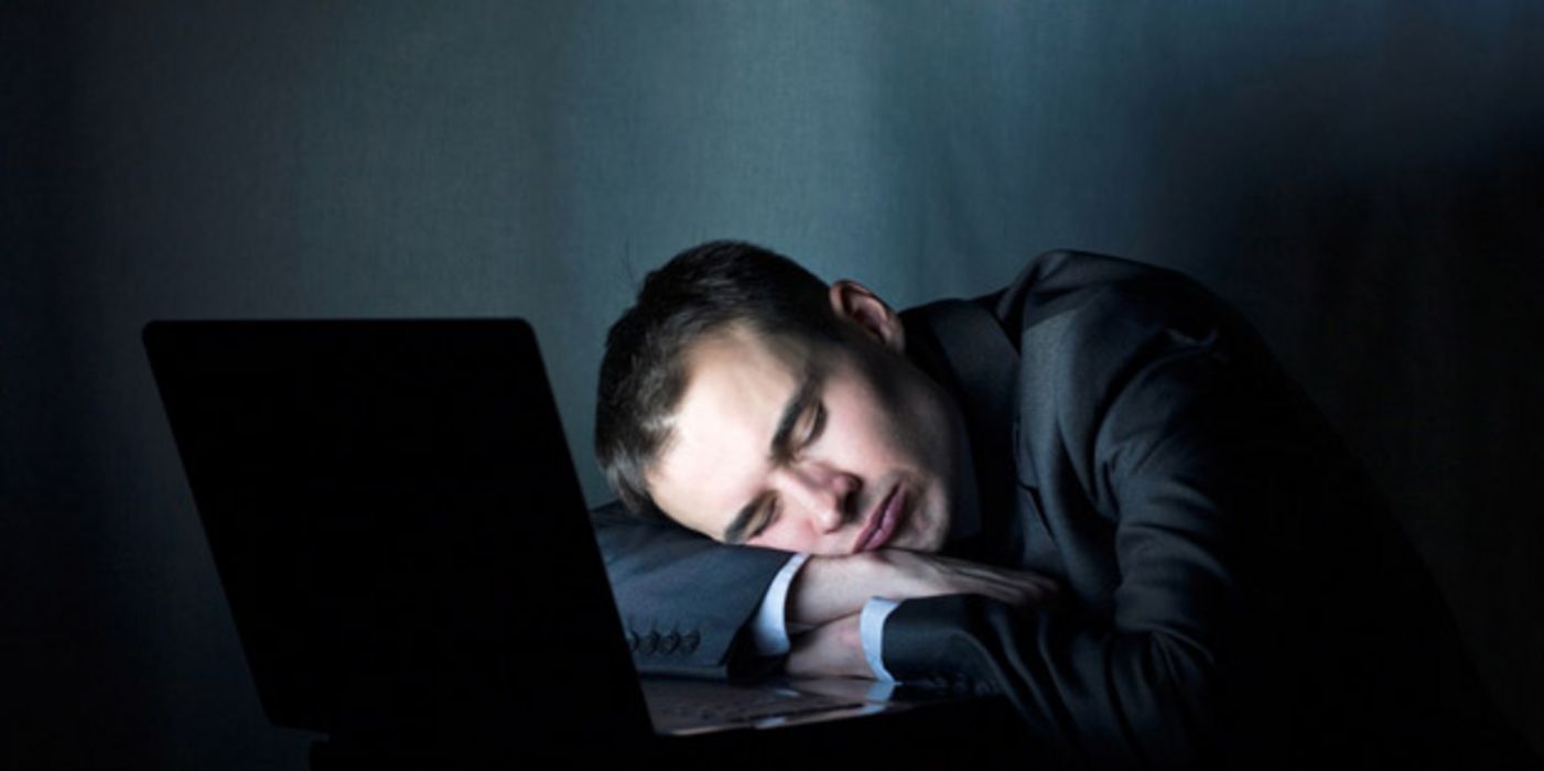 Schlafender Mann vor einem PC