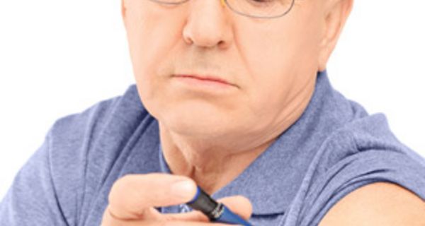 Älterer Mann spritzt sich Insulin in den Oberarm.
