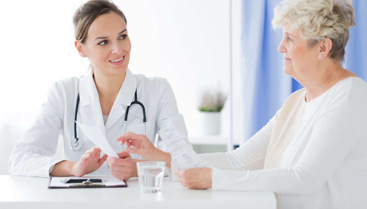 Ärztin im Gespräch mit einer älteren übergewichtigen Patientin.