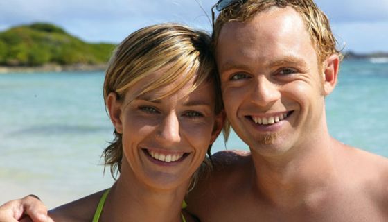 Pärchen mit strahlendem Lächeln am Strand