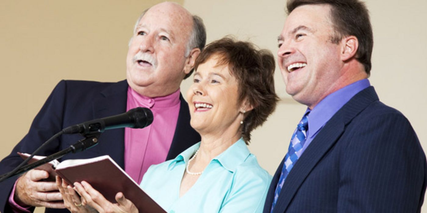 Drei ältere Menschen singen zusammen.