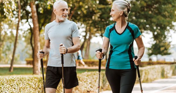 Ein älteres Paar walked gemeinsam durch einen Park.