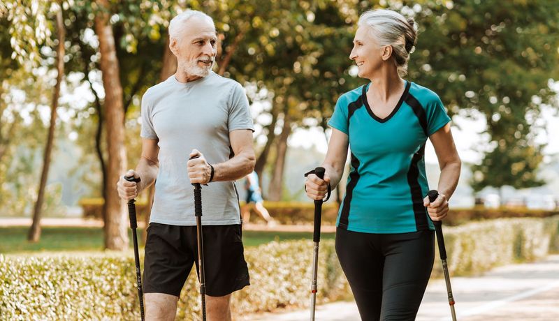 Ein älteres Paar walked gemeinsam durch einen Park.