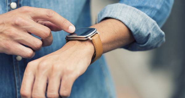 Junger Mann mit Smartwatch am Handgelenk.