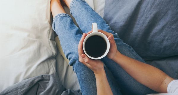 Frau, hält Kaffee in den Händen.