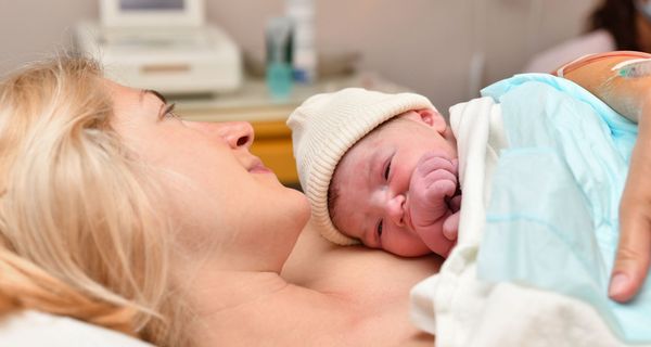 Mutter mit neugeborenem Baby auf der Brust.