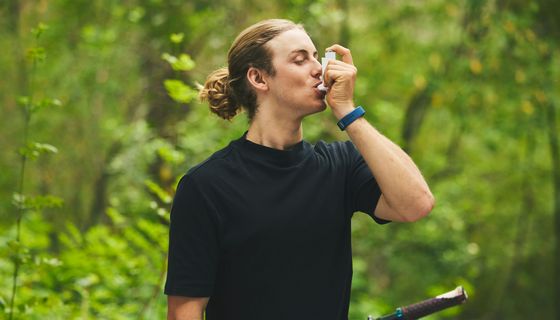 Junger Mann, nutzt Asthmaspray.