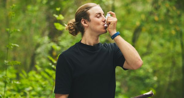 Junger Mann, nutzt Asthmaspray.