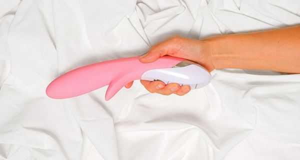 Frau, hält einen Vibrator in der Hand.