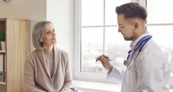 Frau über 50 lässt isch von einem jungen Arzt beraten.