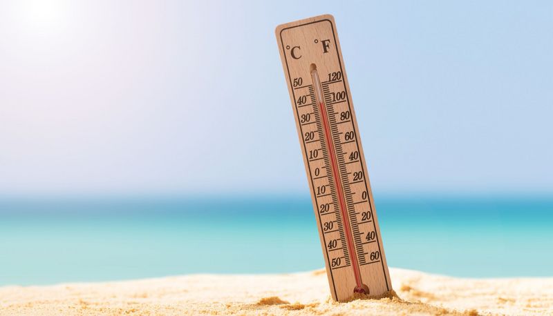 Foto von Thermometer, das im Sand steckt.