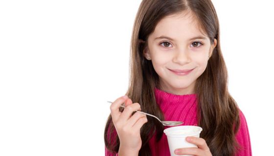 Mädchen isst Joghurt.