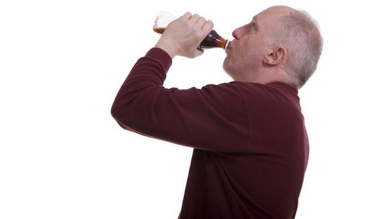 Mann trinkt aus einer kleinen Cola-Flasche
