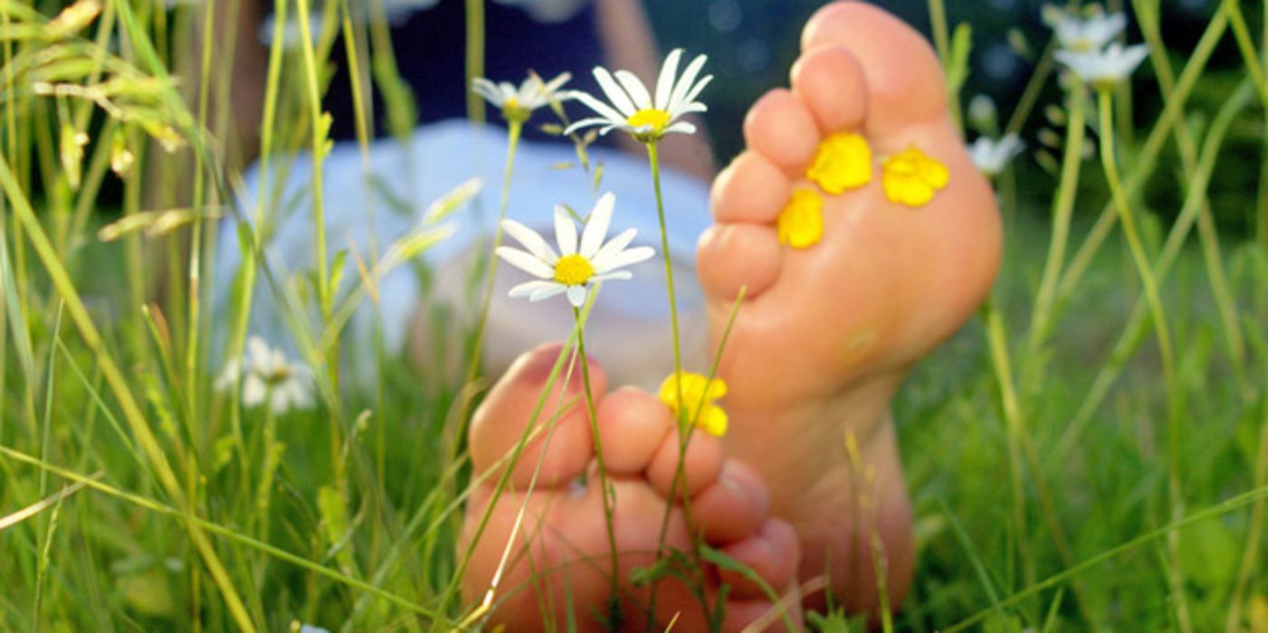 Nackte Füße auf Frühlingswiese