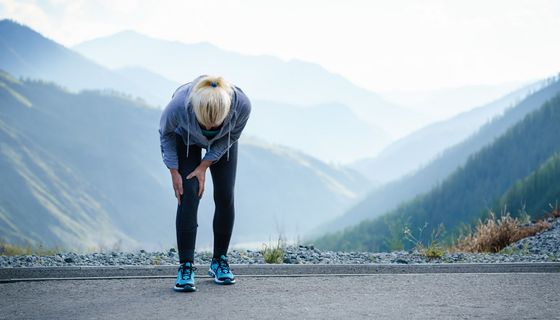 Frau, hält sich das Knie.